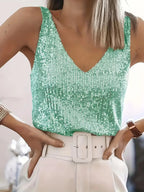 Close-up front view of a green sequin V-neck singlet top with wide straps, paired with a white high-waisted belted skirt