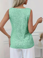 Back view of the green sequin singlet top showing the scoop back and relaxed fit over white trousers