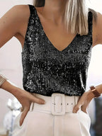 Close-up of a black sequin V-neck singlet top with wide straps paired with a white belted skirt