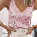 Cropped view of a pink sequin V-neck singlet top with wide straps and a white belted skirt