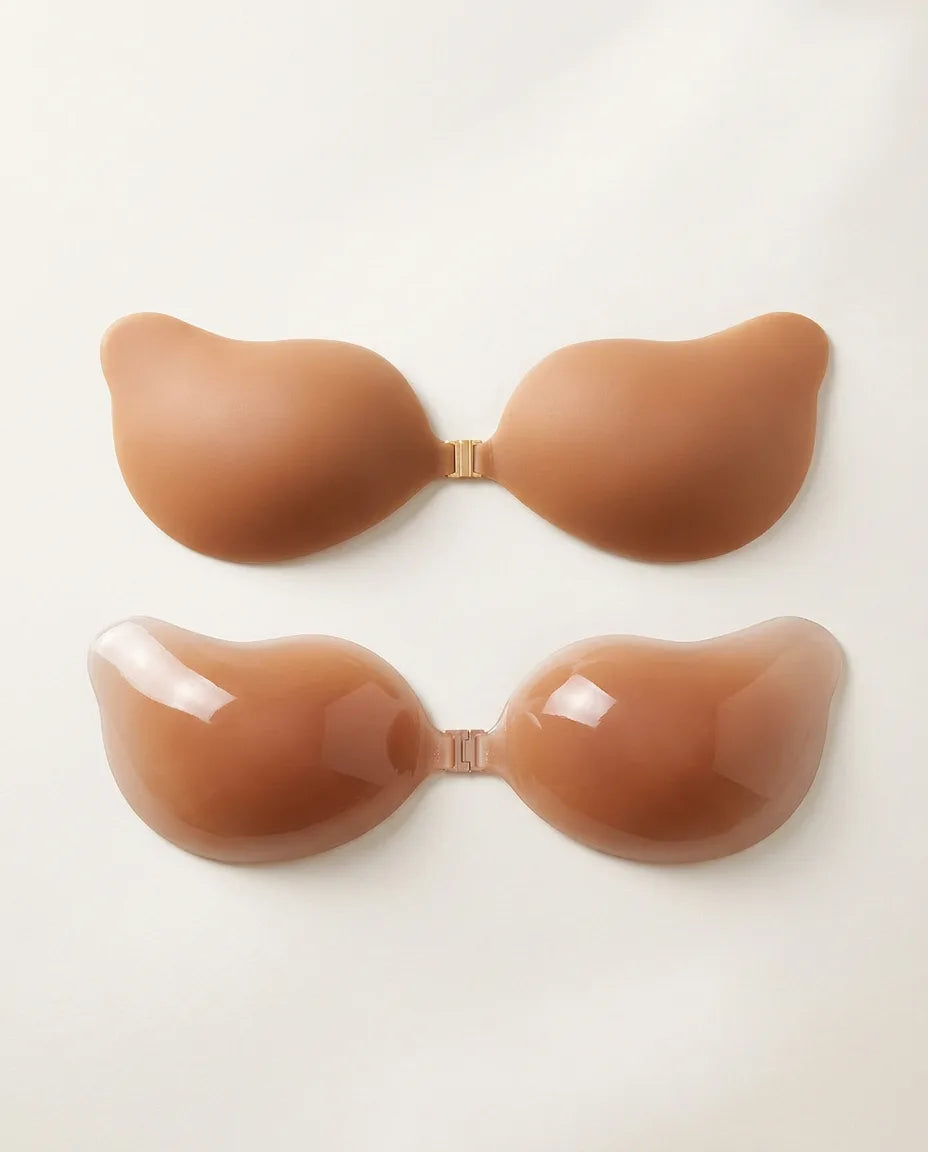 Two tan silicone adhesive bra cups with gold front clasp, shown matte outer surface and glossy inner gel surface