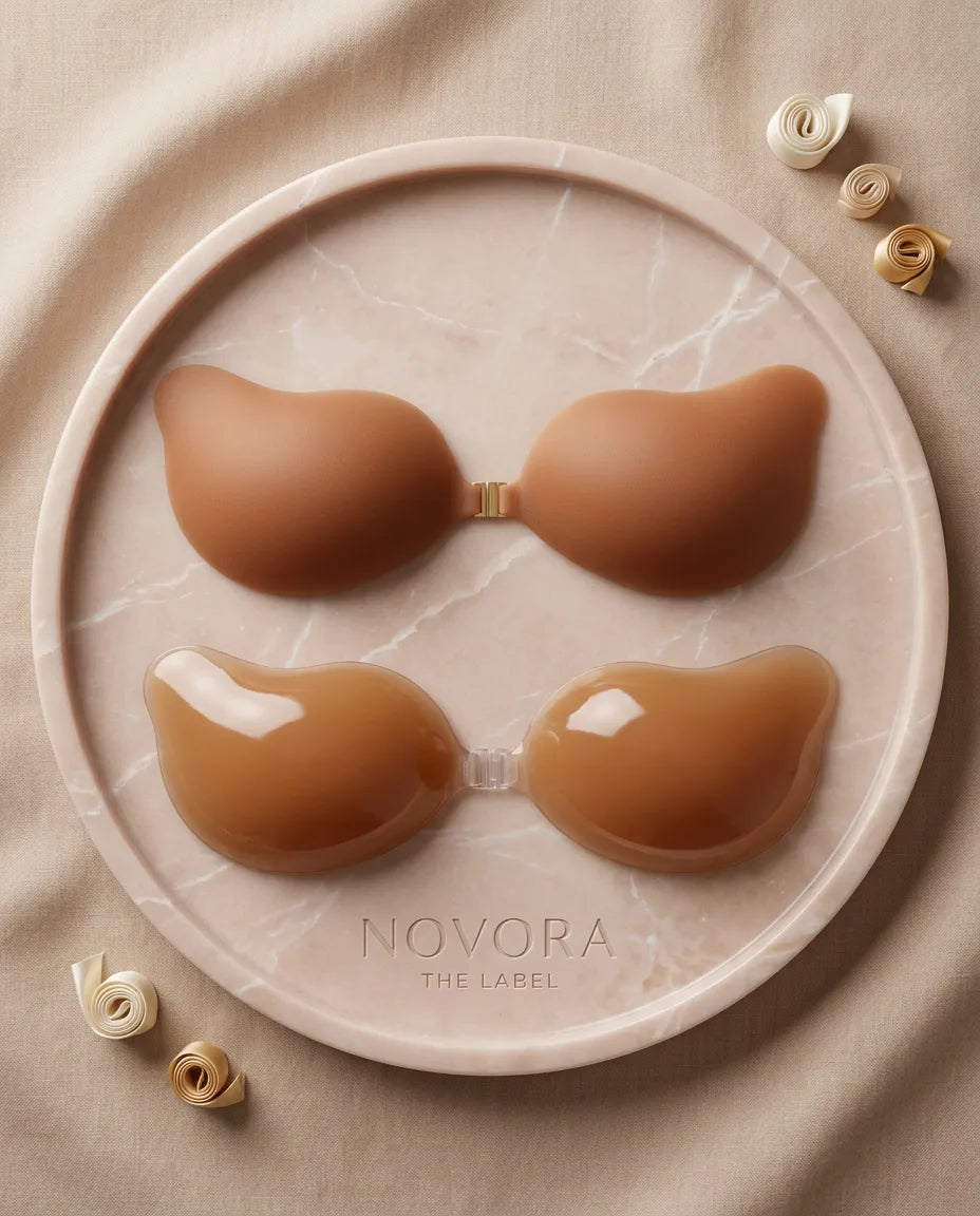 Caramel tan adhesive bra cups shown both matte-side up and gel-side up on a round marble dish with Novora The Label etching