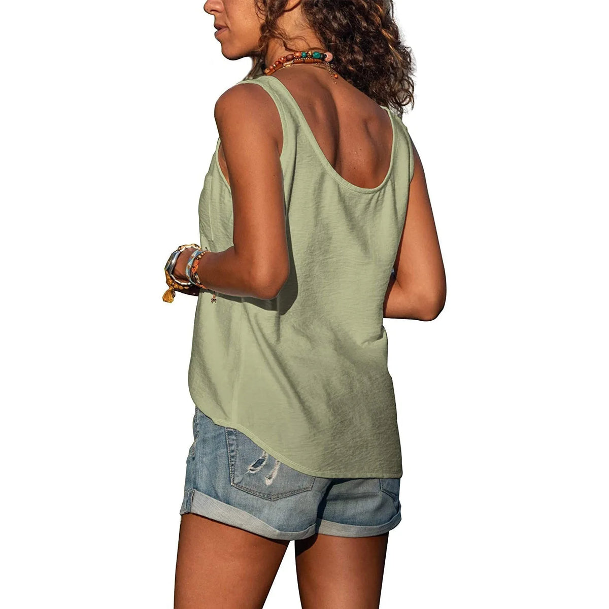 Model wearing the olive green sleeveless top paired with layered beaded necklaces and a leather belt