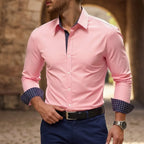 Man wearing a pink slim-fit dress shirt with navy diamond-print contrast cuffs, unbuttoned at the waist