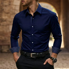 Close-up of a navy blue slim-fit dress shirt with matching tonal dot-print collar and cuff trim