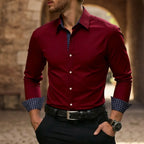 Man wearing a deep burgundy red slim-fit dress shirt with navy diamond-print contrast cuffs