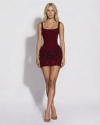 Full-length front view of claret mini dress paired with gold strappy heels