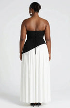 Back view of black and white colourblock dress showing lace-up corset bodice and pleated white skirt