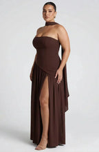 Side view of deep brown strapless maxi dress showing the sweeping skirt and thigh-high slit