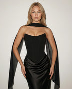 Close-up of the corset bodice, sheer scarf choker and draped satin waist detail in black
