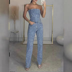 Three-quarter front view of the light blue glitter bandeau top and straight-leg pants paired with clear heeled sandals