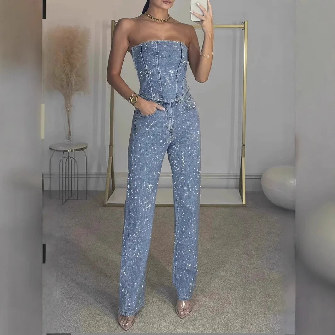 Three-quarter front view of the light blue glitter bandeau top and straight-leg pants paired with clear heeled sandals