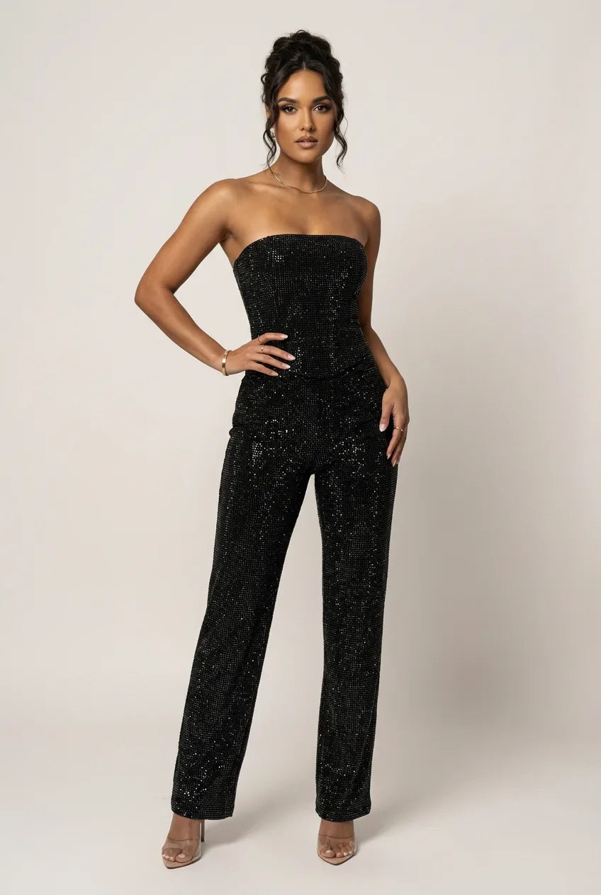 Full-length front view of the black strapless glitter top and straight-leg trousers set on a model with heeled sandals