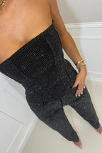 Close-up of the black strapless corset top and high-waist trousers showing the fine all-over sparkle texture