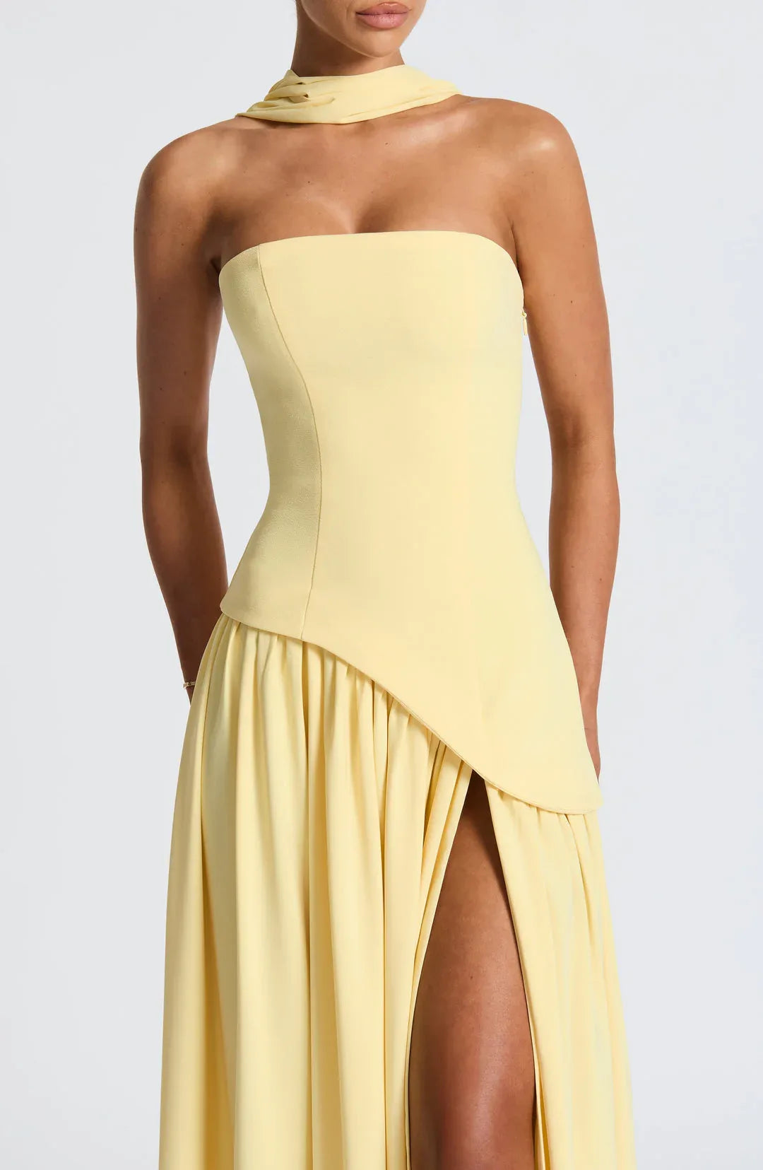 Close-up of strapless yellow bodice with asymmetrical ruched waist and high leg split
