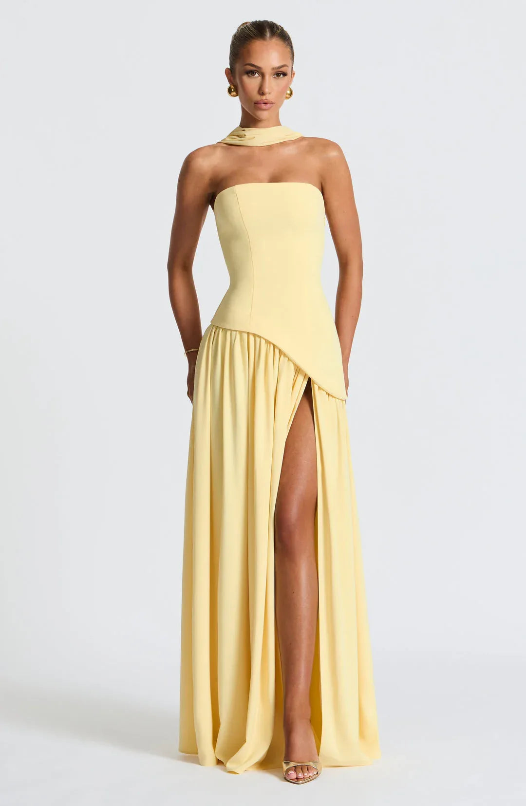 Full-length front view of yellow strapless gown with draped neck scarf and flowing asymmetrical skirt