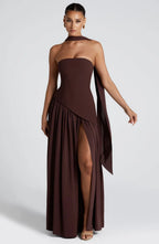 Front view of strapless brown maxi gown with draped scarf over one shoulder and flowing high-slit skirt