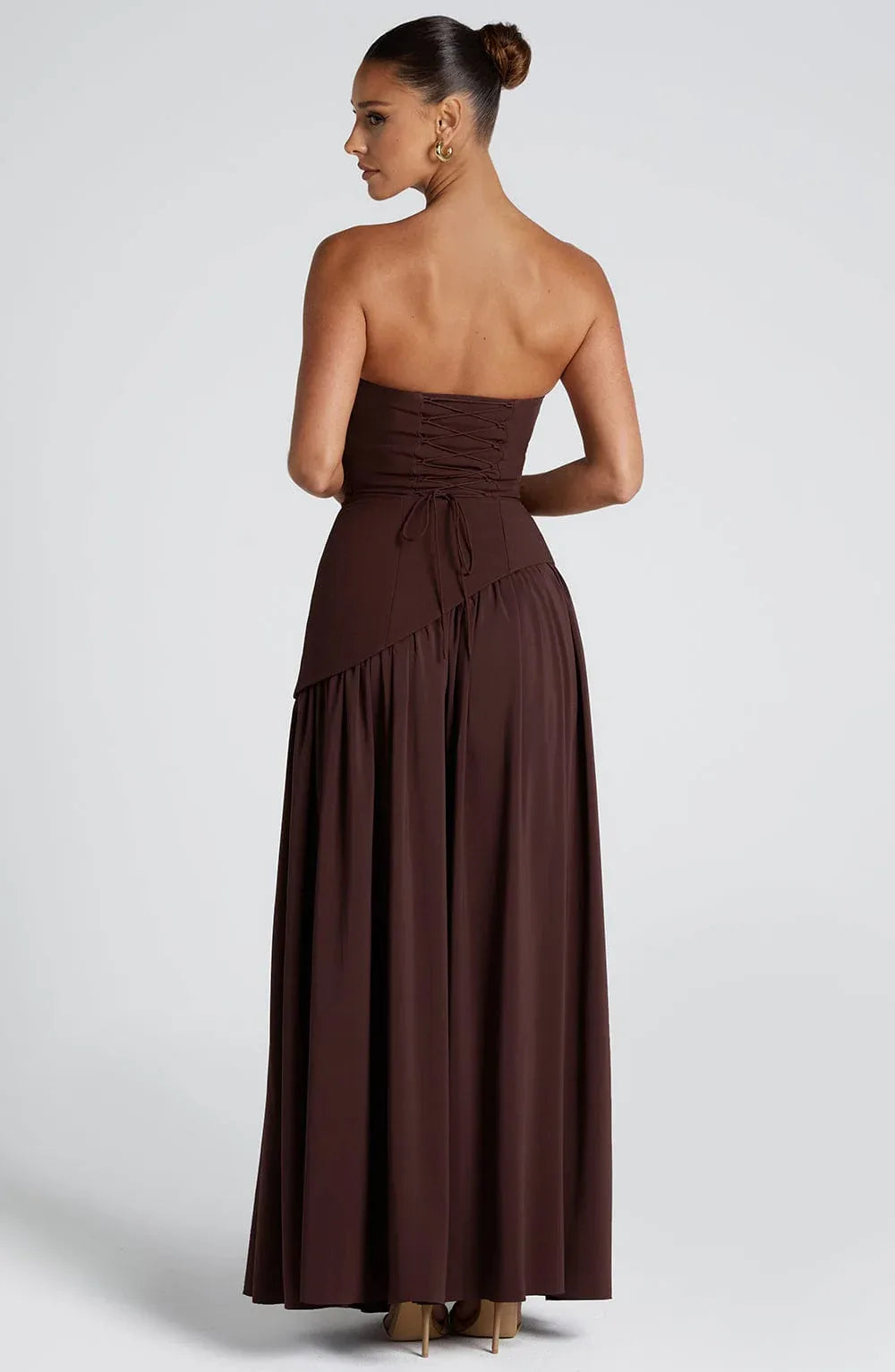 Back view of brown gown showing lace-up corset back and long draped scarf cascading down
