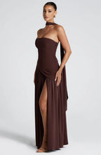 Side profile of brown strapless gown highlighting the fitted column bodice and dramatic leg slit