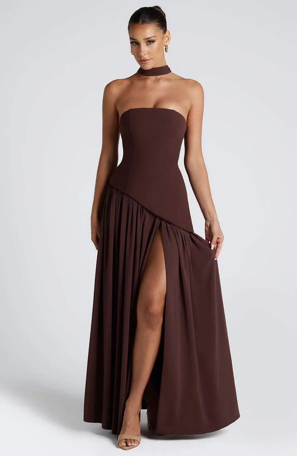 Full-length front view of brown strapless gown with neck scarf detail and gathered asymmetrical hemline