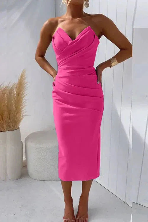 Three-quarter view of the strapless midi dress showing the pleated waist detail and below-knee length