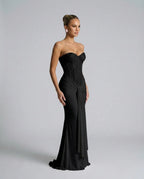 Side profile of the black sequin corset gown showing the fitted boned bodice and gathered fabric knot at the waist