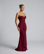 Side angle of the burgundy sequin corset dress highlighting the structured bodice and draped fabric cascading from the waist