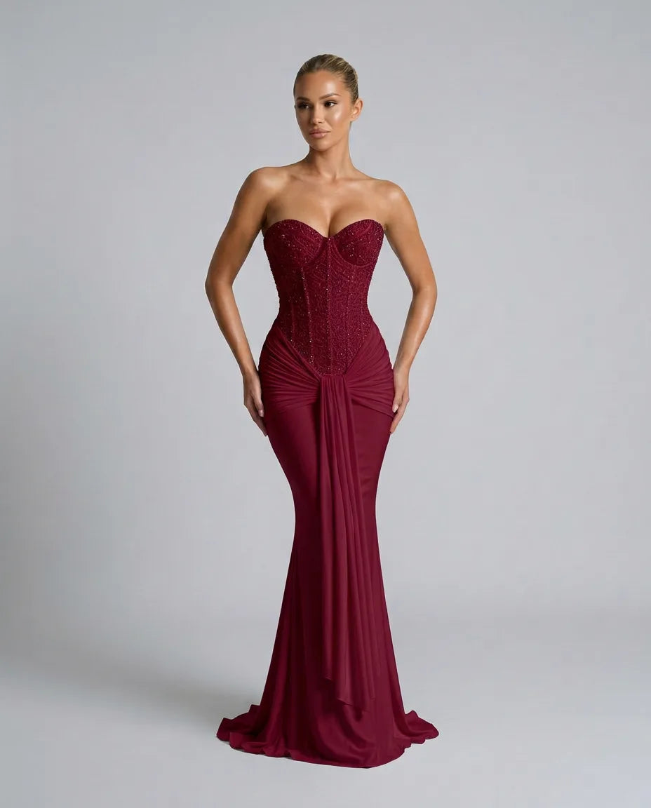 Front view of a burgundy strapless gown with close focus on the beaded sweetheart neckline and gathered waist detail