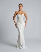 Close front view of the white strapless gown highlighting the sequined corset bodice, sweetheart neckline and waist drape