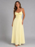 Front view of model in pale yellow strappy maxi dress with ruched sweetheart bodice and tie detail