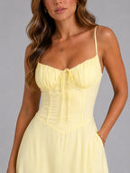 Close-up of ruched bust tie detail and corset-style seaming on the pale yellow bodice