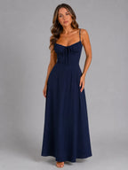 Front view of model wearing the maxi dress in navy with sweetheart neckline and tie front detail