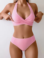 Front view of pink pinstripe halter bikini set showing twist-front top paired with high-waisted bottoms