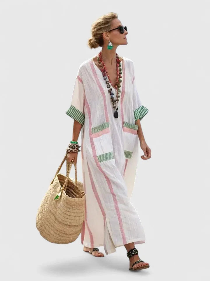White and pink striped linen maxi dress with green trim pockets, V-neck, worn with layered beaded necklaces and a straw tote
