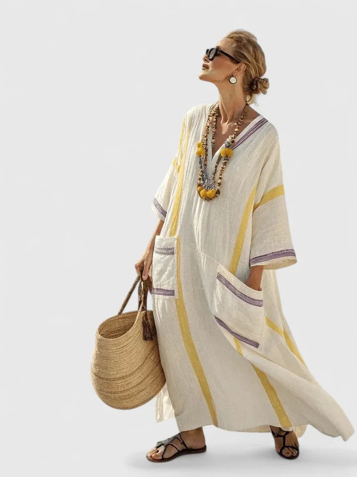 Cream maxi dress with yellow stripes and lilac trim, striped pockets, styled with pom-pom beaded necklace and straw bag
