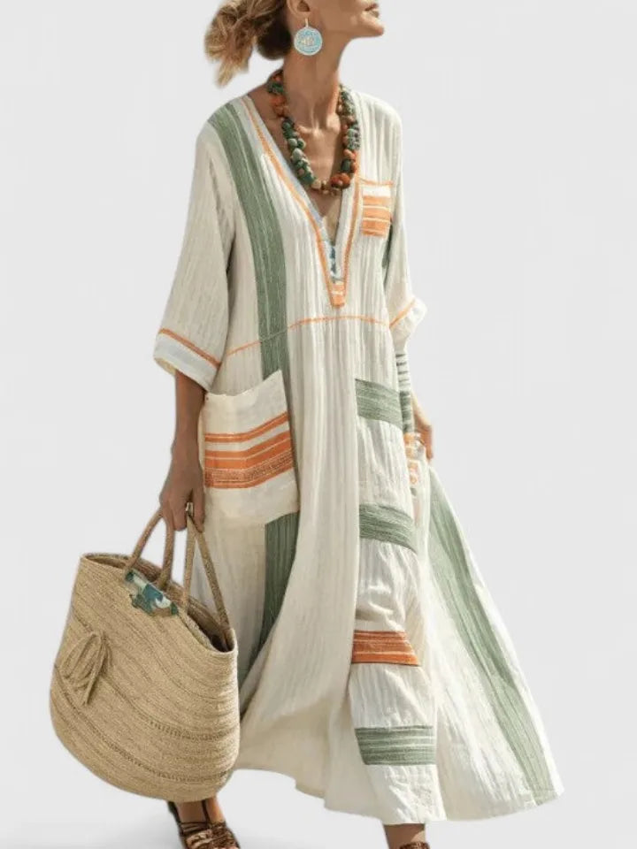 Cream maxi dress with sage green and orange colour-block panels, striped pocket trim, styled with a turquoise beaded necklace