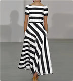 Black and white striped maxi dress on model, highlighting the asymmetric wrap-style skirt and flowing hem