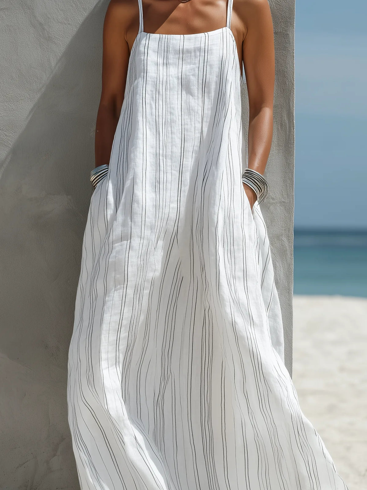 Close-up of the linen-look striped fabric and hand resting in the side pocket of the roomy maxi dress
