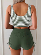 Back view of olive green and white striped tankini top showing scoop back and ruched tie-side shorts