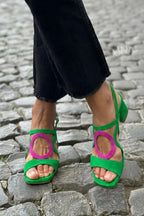 Green suede sandal featuring a contrasting pink oval cut-out detail and wrapped ankle strap