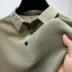 Beige textured polo shirt on a hanger, showing the collar detail and the fabric being held to display its texture.