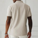 Back view of man wearing apricot textured knit polo shirt, showing ribbed collar and herringbone knit pattern across shoulders