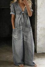 Grey-wash denim jumpsuit with tied V-neck front, puff sleeves and side patch pockets, full length view