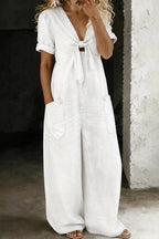 Off-white denim jumpsuit with tie-front neckline, rolled short sleeves and wide-leg silhouette