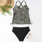 Flat lay of leopard print ruched tankini top with crossback straps paired with black high-waisted bottoms