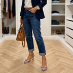 Styled outfit shot of the two-tone bow heels paired with cuffed jeans, a navy blazer and a tan handbag