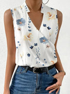 Sleeveless top in a blue and yellow wildflower print with a notched collar and crossover front panel