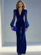 Full-length front view of the royal blue velvet jumpsuit paired with a matching clutch and heels