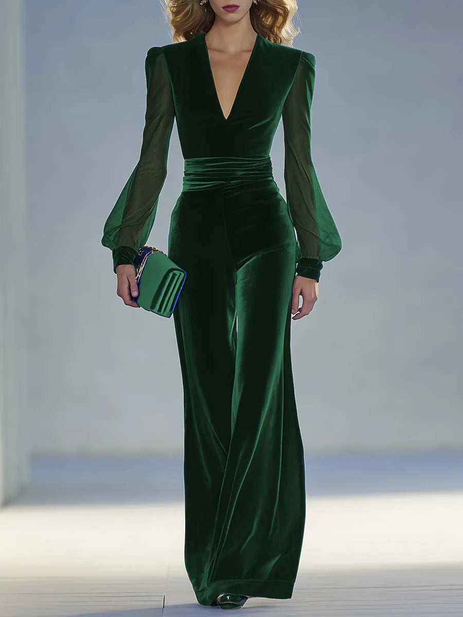 Close-up front view of the dark green velvet jumpsuit highlighting the V-neckline and sheer sleeves