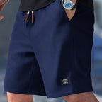 Navy blue waffle-knit shorts with elasticated waistband and leather-tipped drawstrings